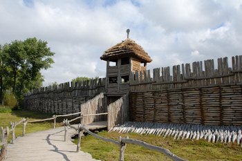 Animacja przedstawiająca grupę turystów odwiedzającą archeologiczny rezerwat w Biskupinie, ilustrująca aktywności podczas wycieczki szkolnej na Szlaku Piastowskim